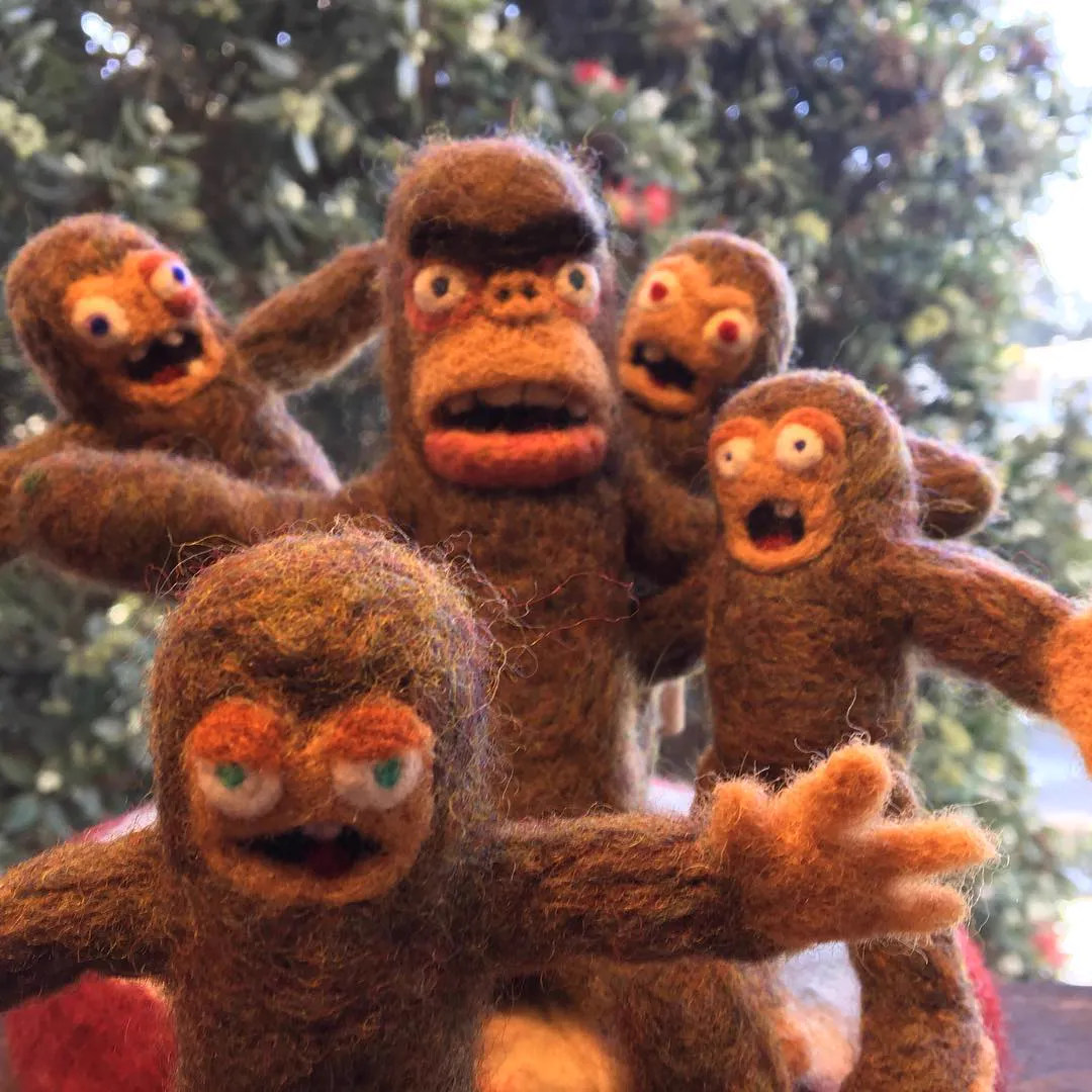 A family of five brown felted Bigfoot creatures with startled expressions